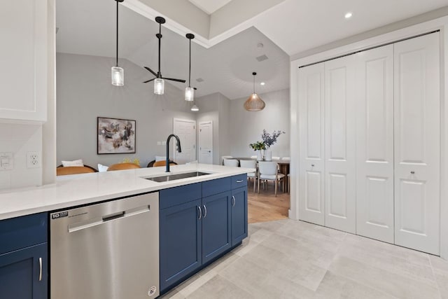kitchen with a peninsula, a sink, dishwasher, decorative light fixtures, and blue cabinetry
