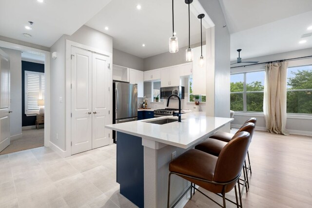 kitchen with a peninsula, baseboards, a breakfast bar area, light countertops, and stainless steel appliances