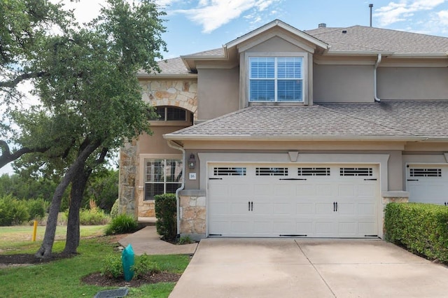 view of front of home with stucco siding, stone siding, and concrete driveway