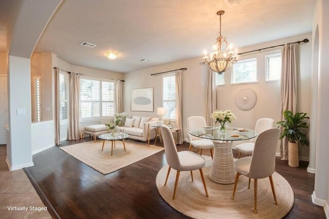 dining room featuring arched walkways, visible vents, plenty of natural light, and a chandelier