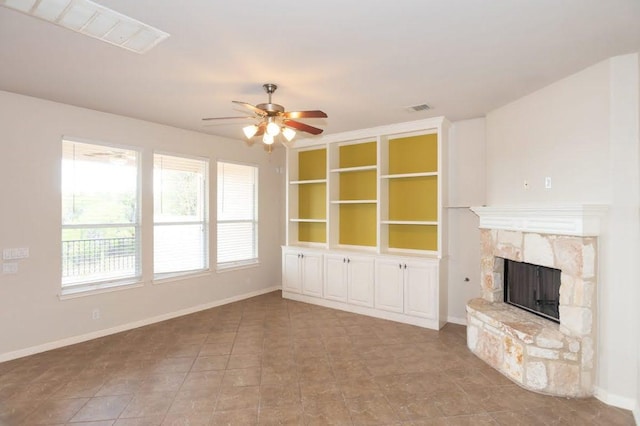 7901 SW Pkwy Unit 16, Austin, TX 78735 - unfurnished living room with ceiling fan, a stone fireplace, and tile patterned flooring