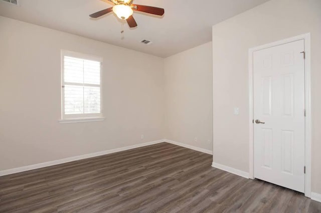 unfurnished room featuring visible vents, dark wood-type flooring, baseboards, and ceiling fan