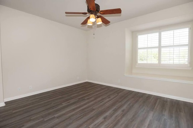 empty room with baseboards, ceiling fan, and dark wood-style flooring