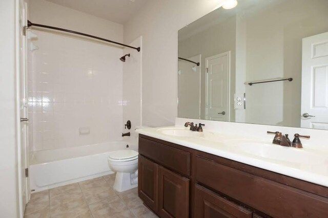 full bathroom featuring a sink, double vanity, toilet, and  shower combination