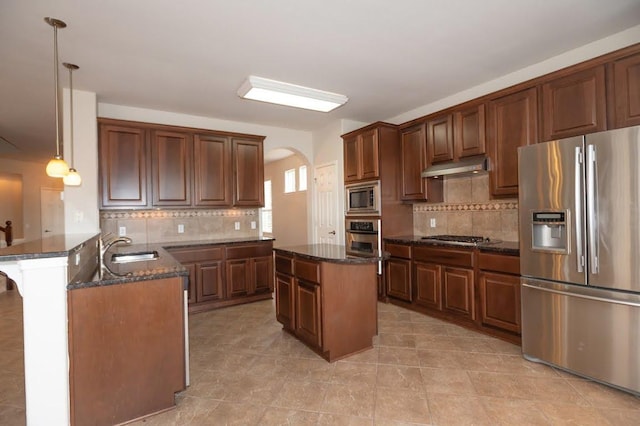 kitchen featuring a sink, tasteful backsplash, stainless steel appliances, and a peninsula