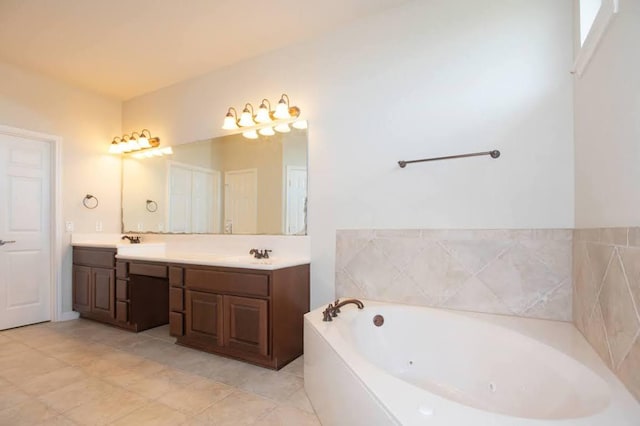 full bathroom with a jetted tub, double vanity, a sink, and tile patterned flooring
