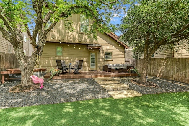 rear view of house with fence, a wooden deck, board and batten siding, and outdoor lounge area