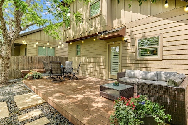 wooden terrace with fence, outdoor dining space, and outdoor lounge area