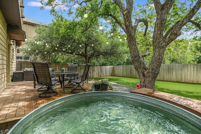 view of swimming pool featuring outdoor dining area, a wooden deck, and a fenced backyard