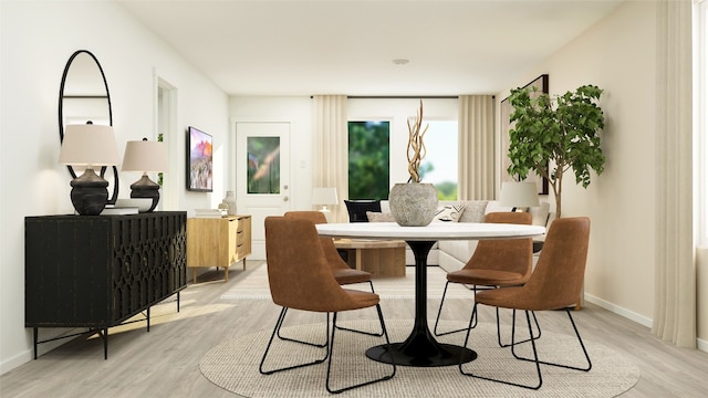dining area featuring baseboards and light wood-style flooring