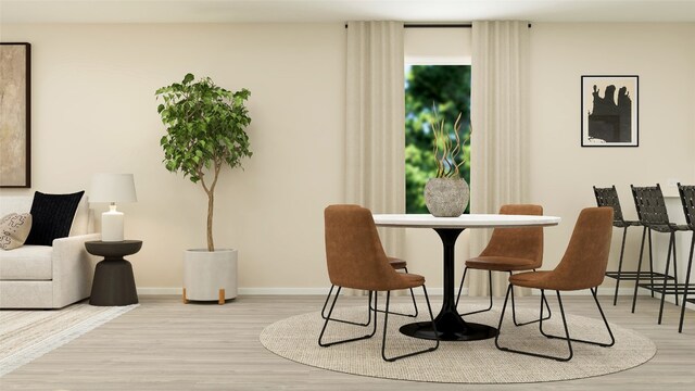 dining space featuring baseboards and wood finished floors