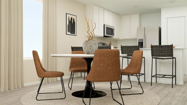 kitchen featuring white refrigerator with ice dispenser, light wood-type flooring, baseboards, stainless steel microwave, and white cabinetry