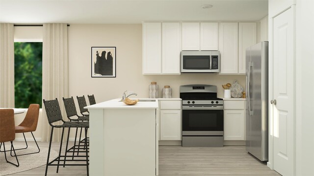 kitchen with light countertops, appliances with stainless steel finishes, light wood-style flooring, and white cabinetry