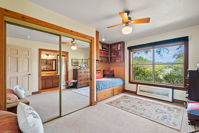 bedroom featuring baseboards, ceiling fan, carpet, and a closet