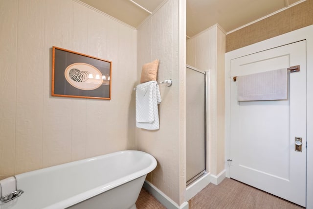 bathroom with a freestanding bath, baseboards, and a stall shower