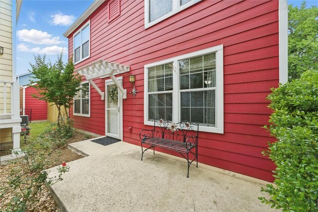 property entrance with a patio area and a pergola