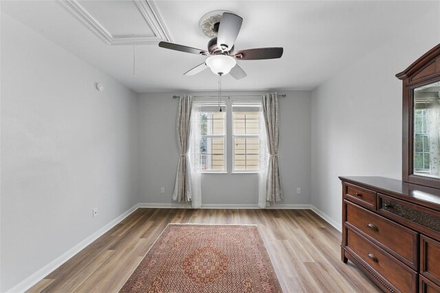 empty room featuring ceiling fan, plenty of natural light, light wood-style flooring, and attic access