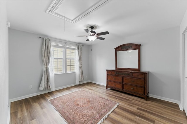 bedroom with baseboards, attic access, and wood finished floors