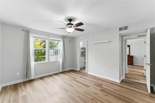 unfurnished bedroom featuring baseboards, visible vents, ceiling fan, and light wood-type flooring