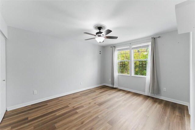 unfurnished room featuring baseboards, a ceiling fan, and wood finished floors