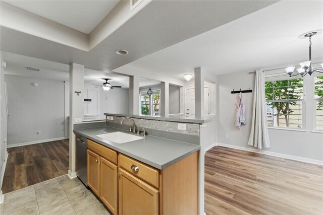 kitchen featuring plenty of natural light, a sink, baseboards, and dishwasher