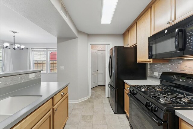 kitchen featuring decorative backsplash, baseboards, a chandelier, a sink, and black appliances