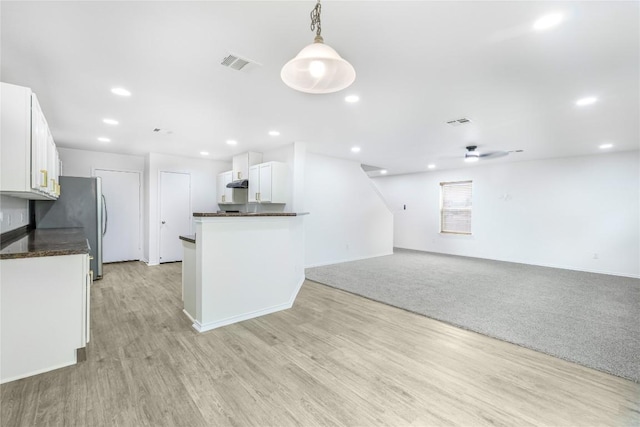 kitchen featuring visible vents, dark countertops, light wood-style floors, white cabinetry, and a ceiling fan