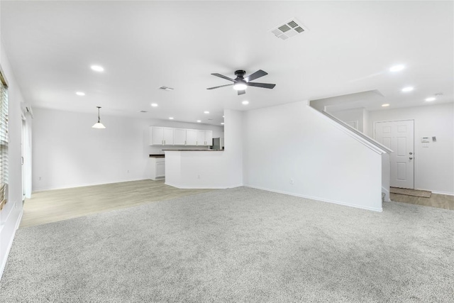 unfurnished living room featuring visible vents, baseboards, ceiling fan, light colored carpet, and recessed lighting