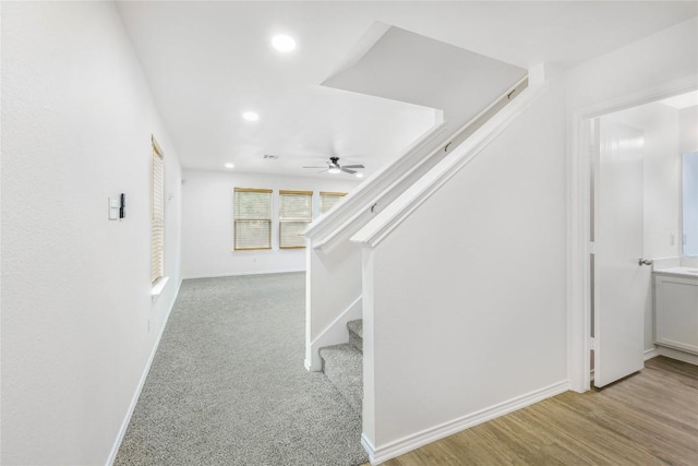 staircase featuring a ceiling fan, baseboards, recessed lighting, and wood finished floors