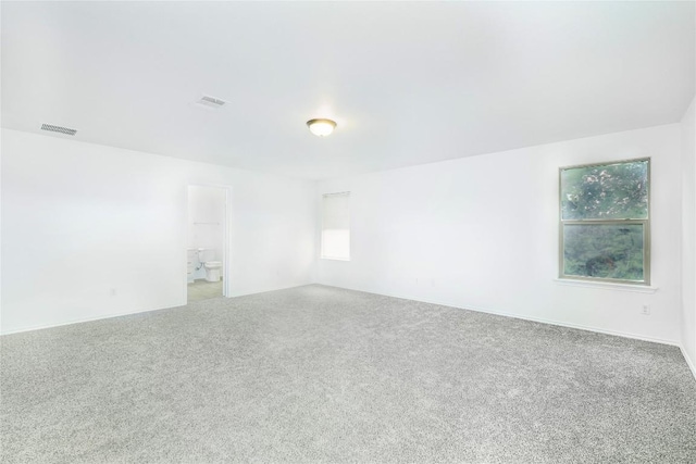 carpeted spare room featuring visible vents