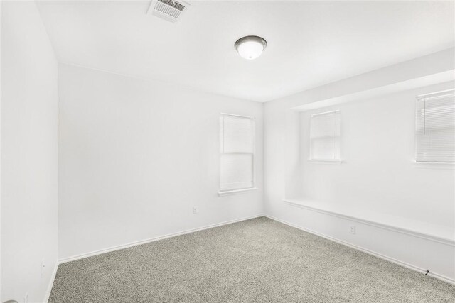 carpeted empty room with baseboards and visible vents