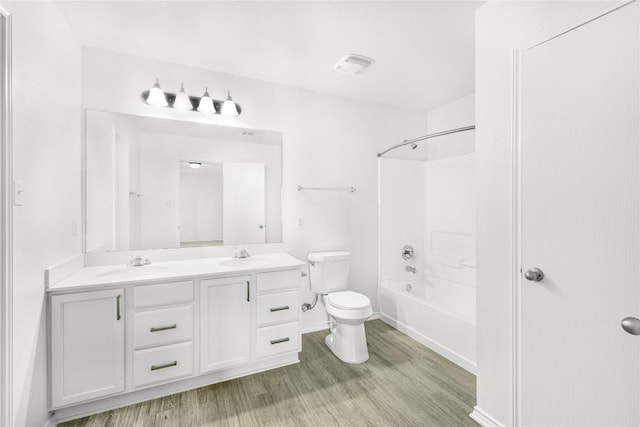 full bath featuring a sink, double vanity, toilet, and wood finished floors