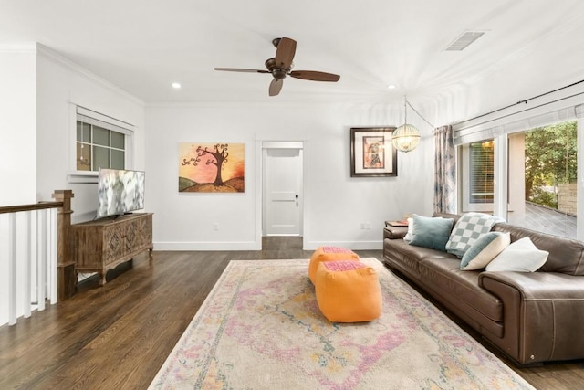 living room with visible vents, ornamental molding, baseboards, a ceiling fan, and dark wood finished floors