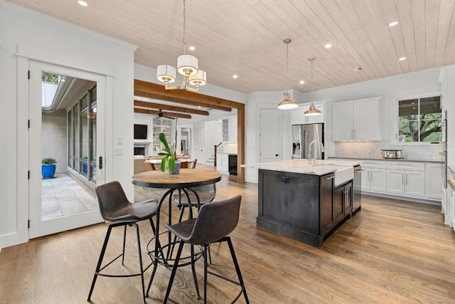 kitchen with recessed lighting, light wood-type flooring, wood ceiling, a sink, and stainless steel appliances