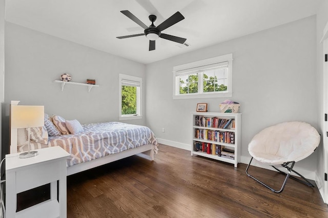 bedroom with a ceiling fan, baseboards, visible vents, and wood finished floors