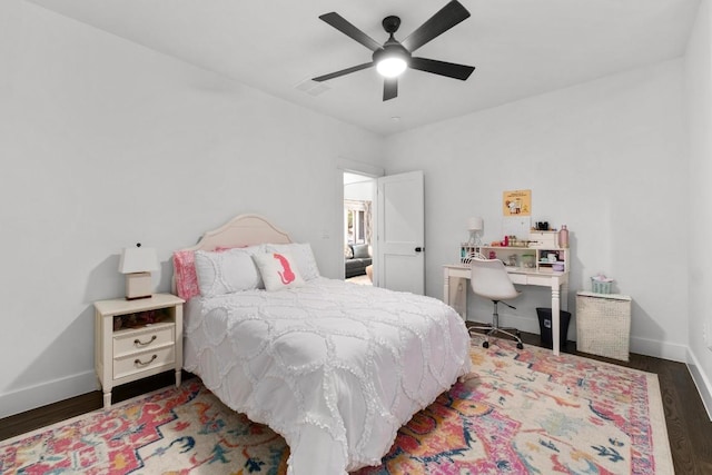 bedroom featuring a ceiling fan, baseboards, visible vents, and wood finished floors