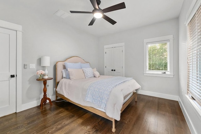 bedroom with a ceiling fan, baseboards, dark wood finished floors, and visible vents