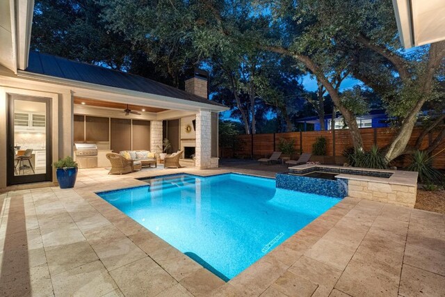 view of swimming pool with ceiling fan, a patio, a fenced backyard, an outdoor hangout area, and exterior kitchen