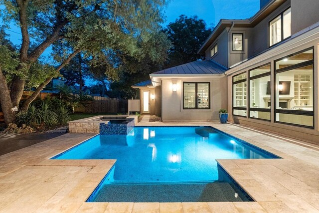 view of swimming pool featuring a pool with connected hot tub, fence, and a patio area