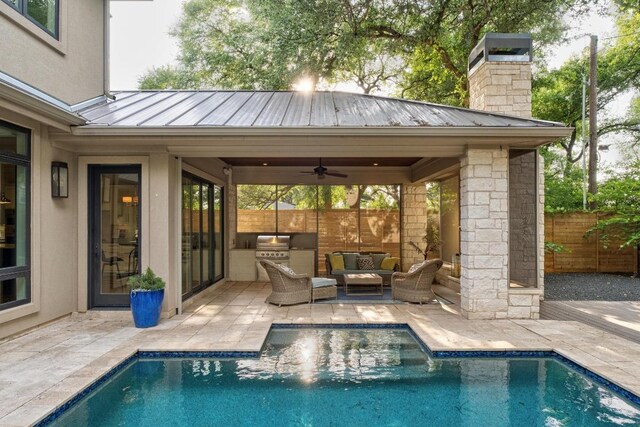 view of pool featuring a patio area, fence, a fenced in pool, an outdoor hangout area, and an outdoor kitchen