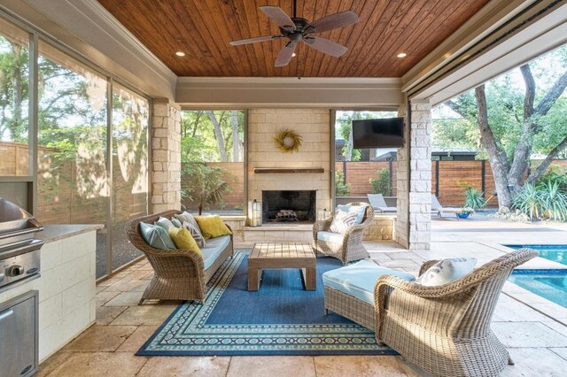 sunroom featuring a healthy amount of sunlight, exterior kitchen, and ceiling fan