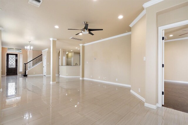 unfurnished living room featuring visible vents, ornamental molding, baseboards, and ceiling fan with notable chandelier