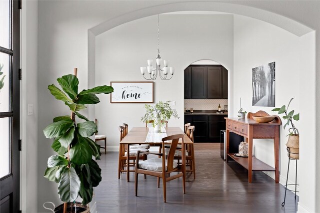 dining room featuring an inviting chandelier, baseboards, dark wood-style floors, and a healthy amount of sunlight