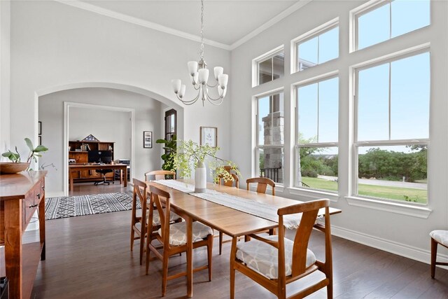 dining room featuring crown molding, arched walkways, baseboards, dark wood-style floors, and a chandelier