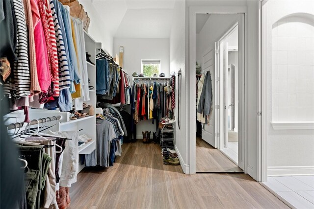 walk in closet with wood finished floors