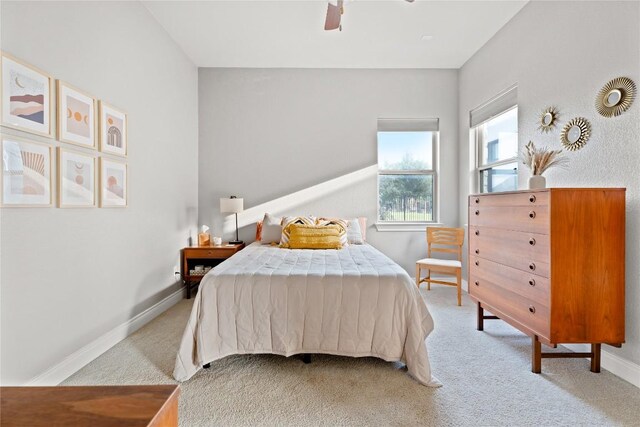 bedroom featuring baseboards, light carpet, and ceiling fan