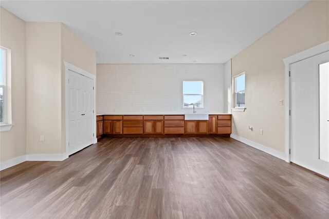 interior space with a sink, baseboards, and wood finished floors