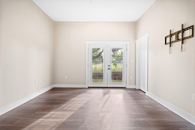 empty room with french doors, baseboards, and wood finished floors