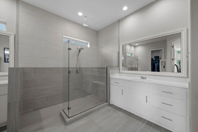 full bath with vanity, tile patterned flooring, a walk in closet, and a stall shower