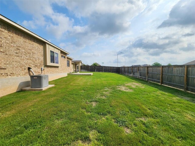 view of yard with a fenced backyard and central AC